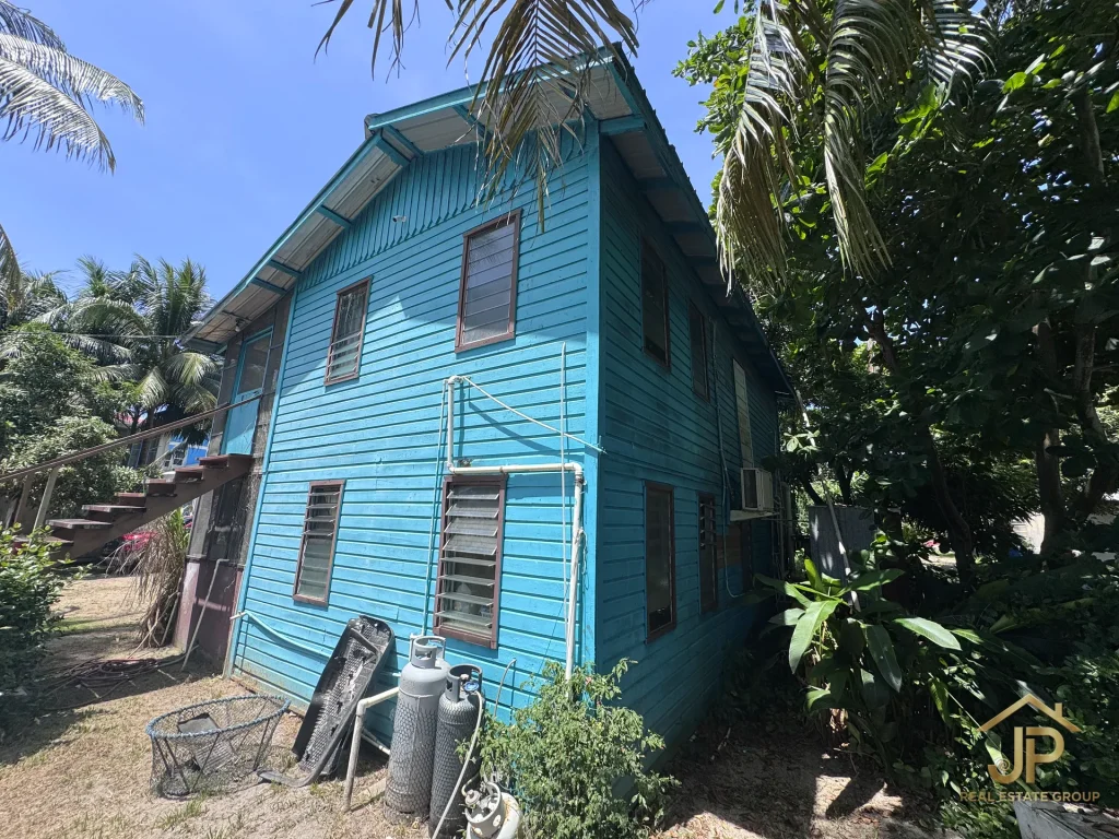 canal-side duplex property with tropical landscaping in Placencia Village - JP Real Estate Group