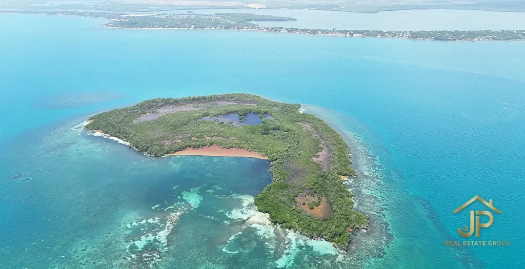 Aerial view of the private island with Placencia Peninsula in the distance