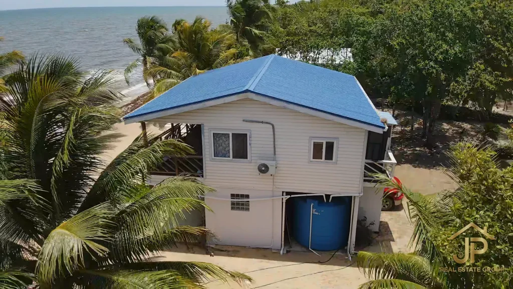 Elevated main house with blue roof at Mayacan beachfront property